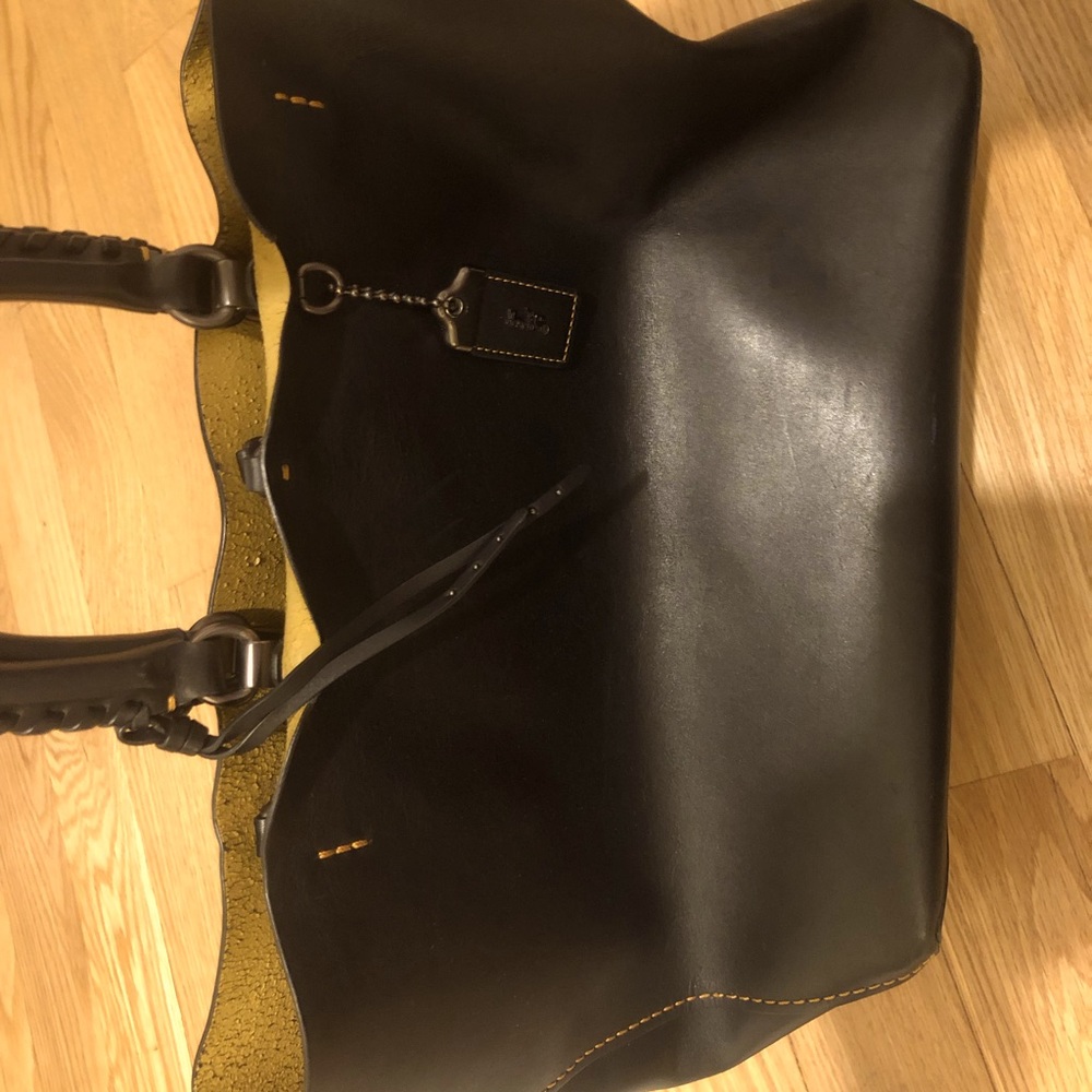 Black leather Rogue Coach bag with whipstitch handles.